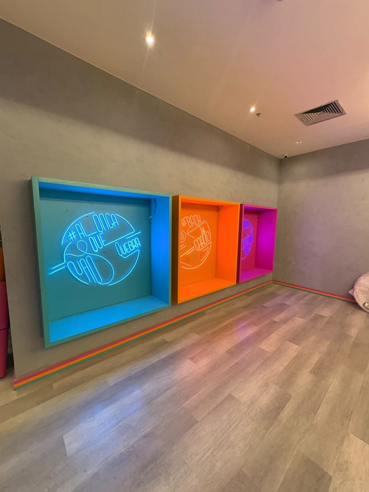 Sala com nichos iluminados em azul, laranja e rosa