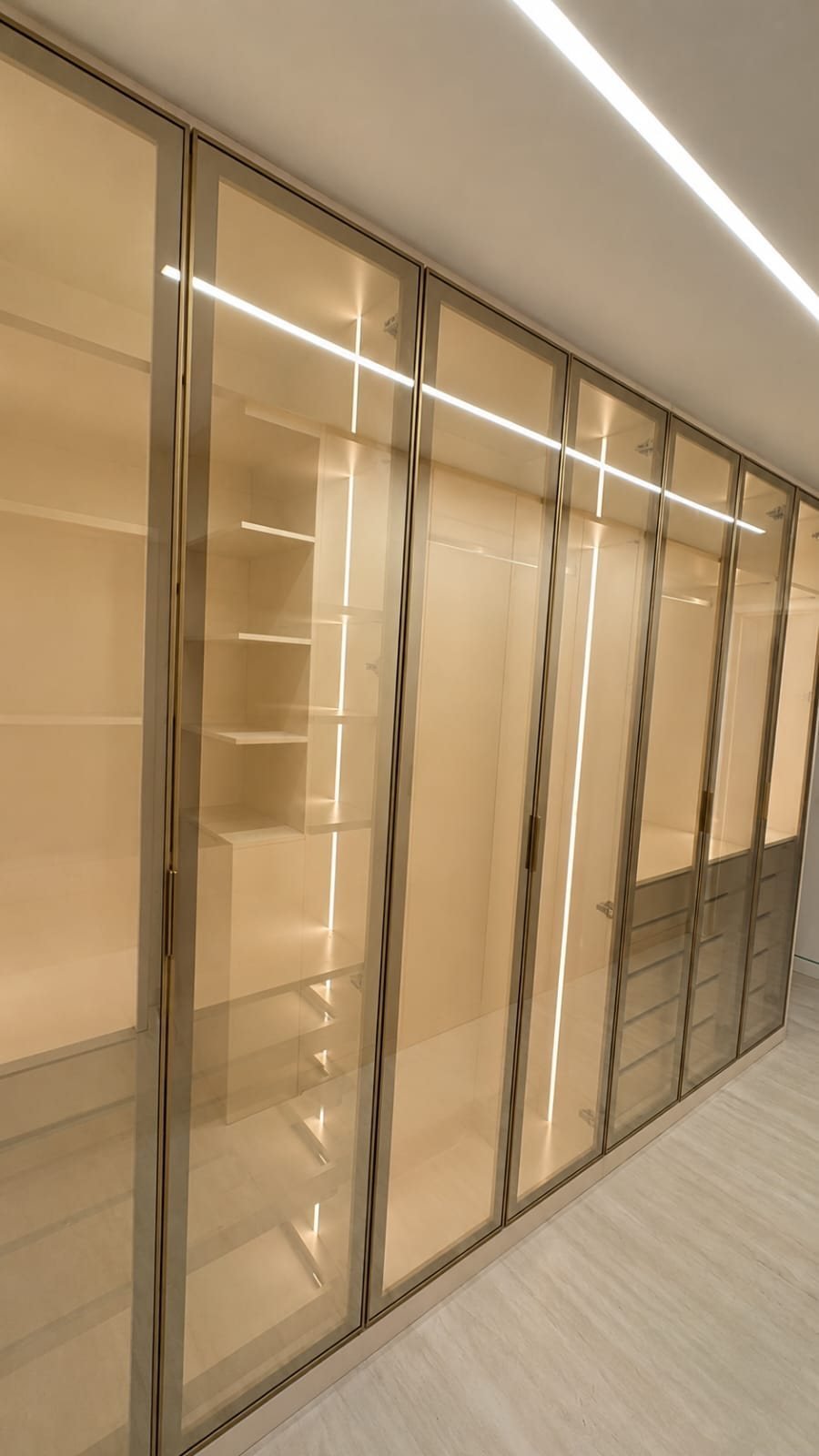Closet com portas de vidro e iluminação em LED